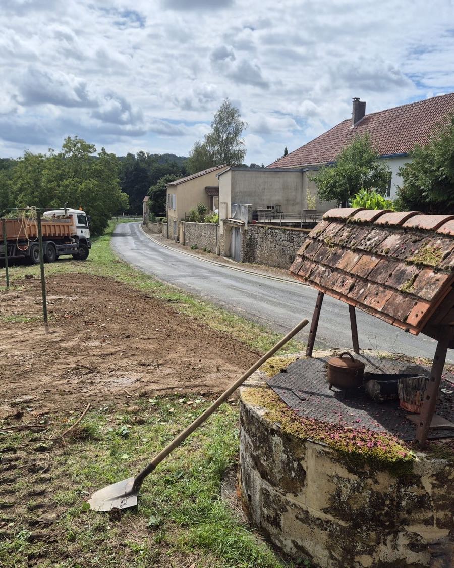 Camion benne et mini-pelle sur un chantier en bordure de voie